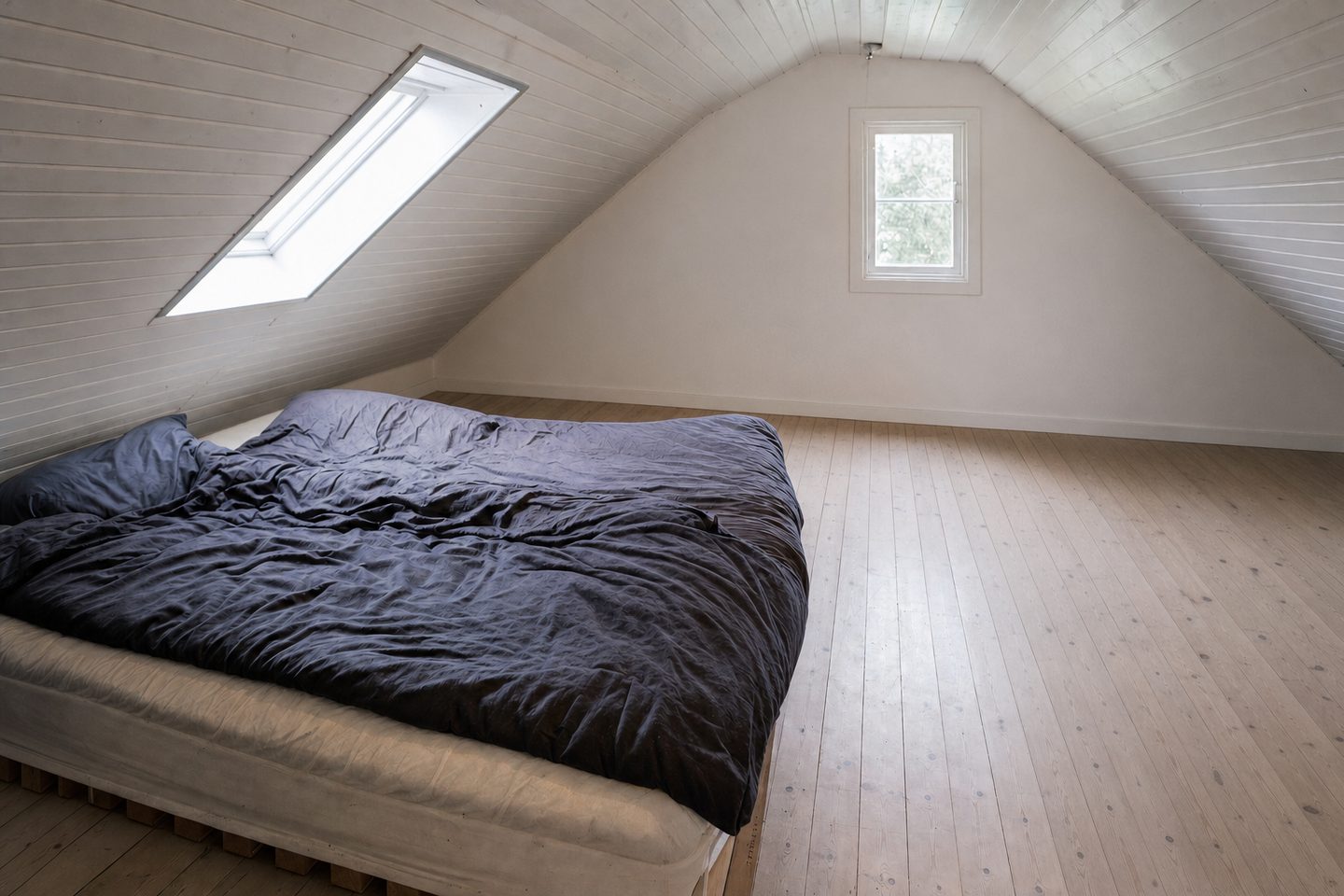 An attic bedroom with a skylight — Decluttered