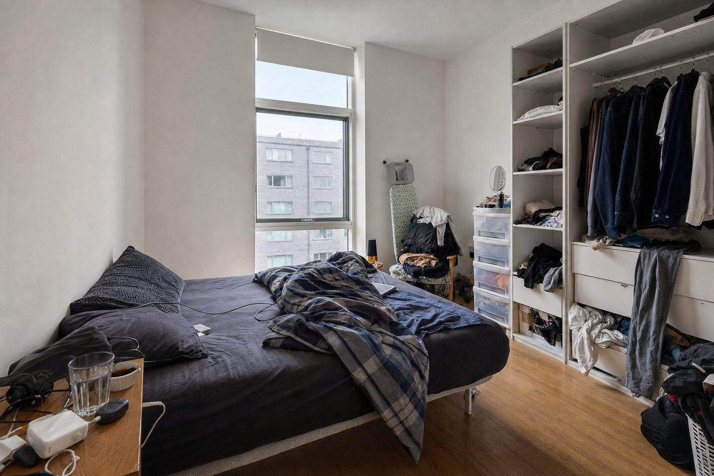 Un dormitorio de piso en la ciudad con una ventana alta — Original