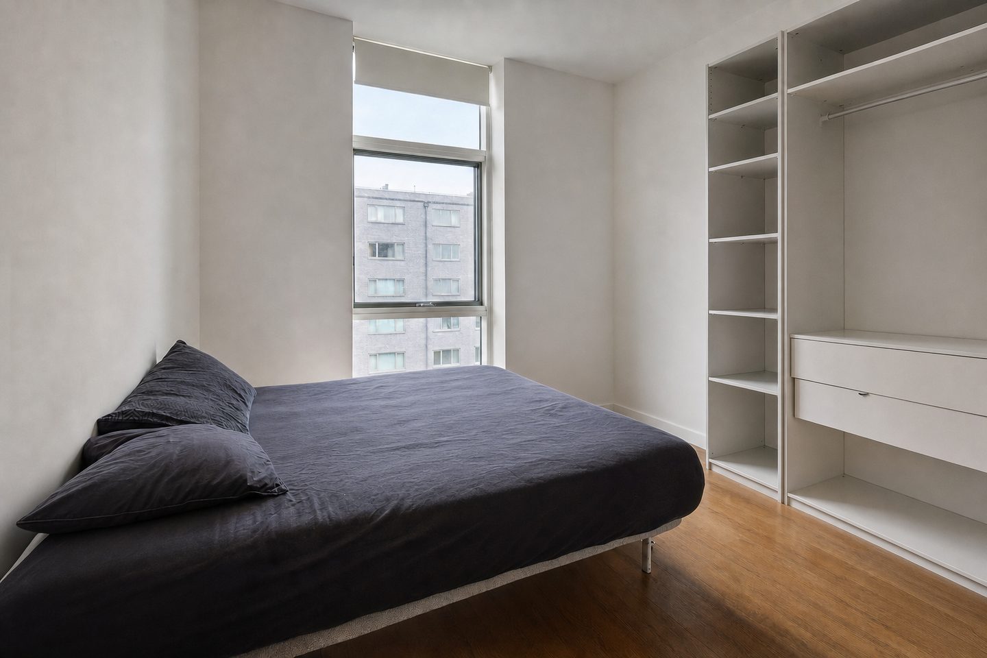Un dormitorio de piso en la ciudad con una ventana alta — Despejado