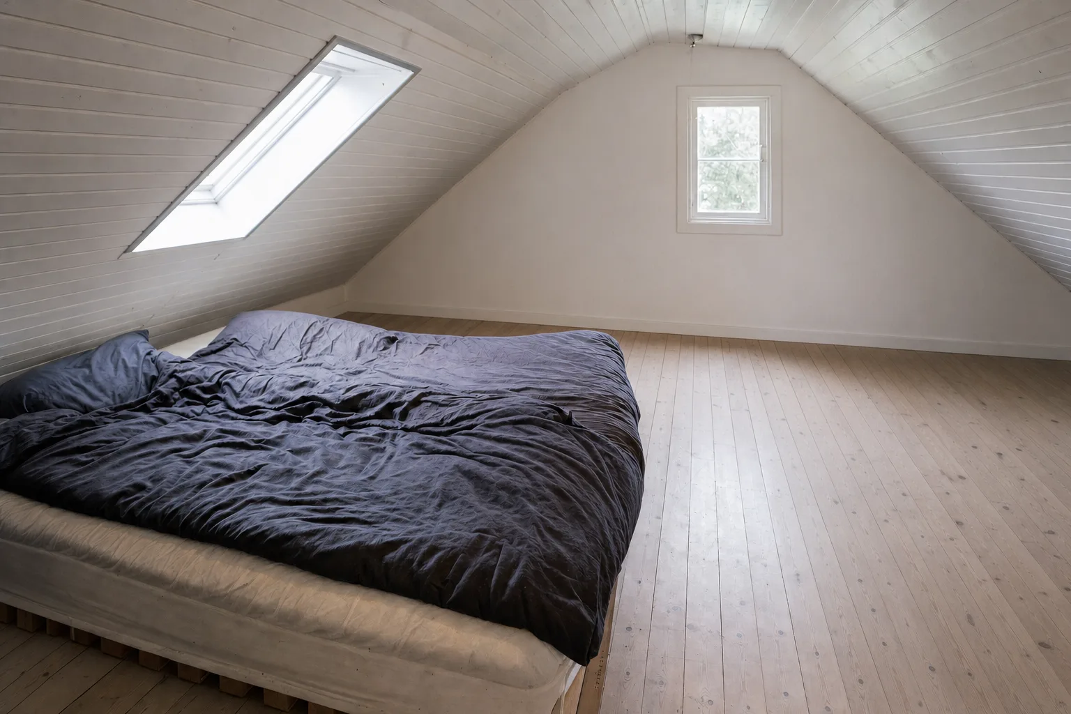 An attic bedroom with a skylight — Decluttered