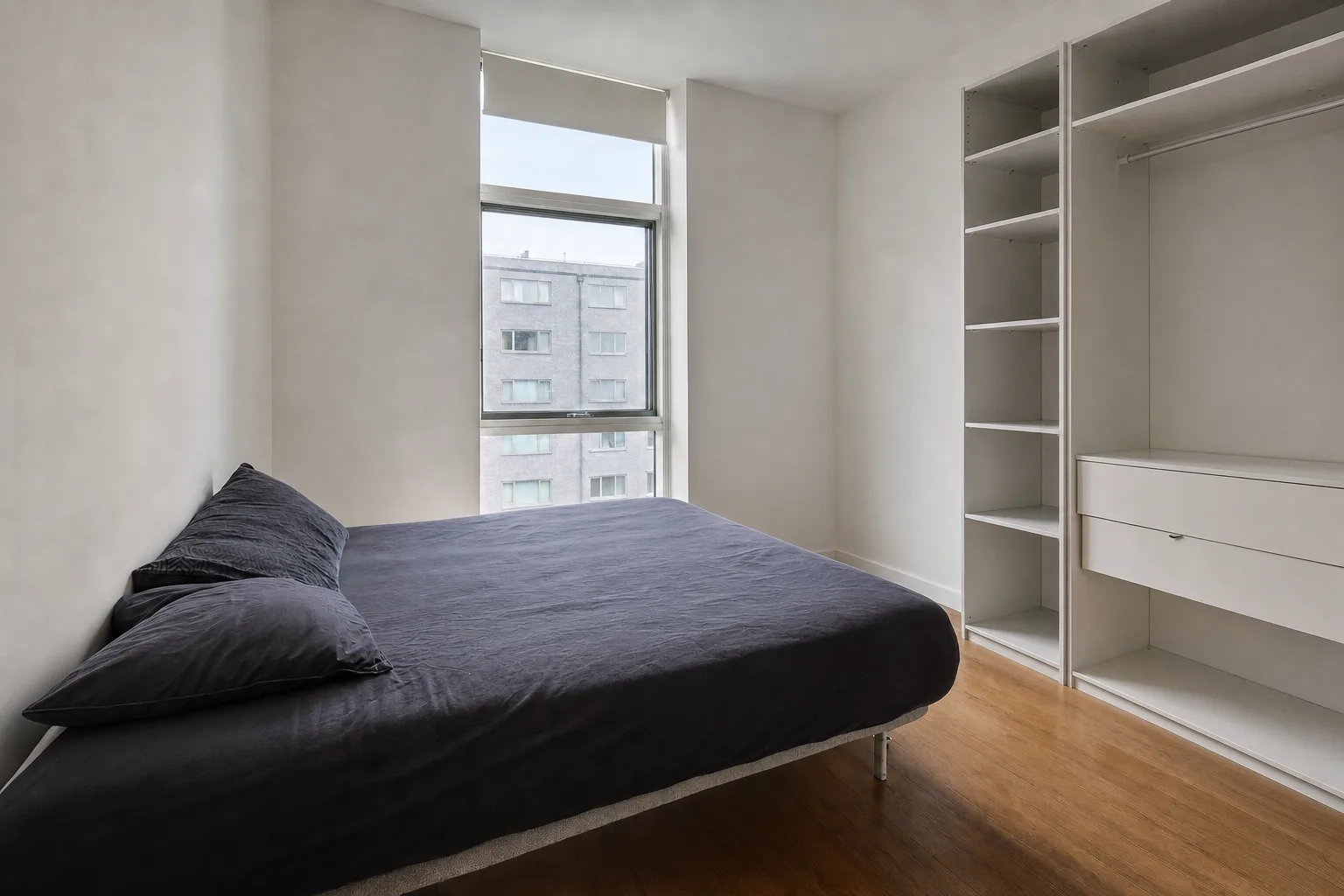 Un dormitorio de piso en la ciudad con una ventana alta — Despejado